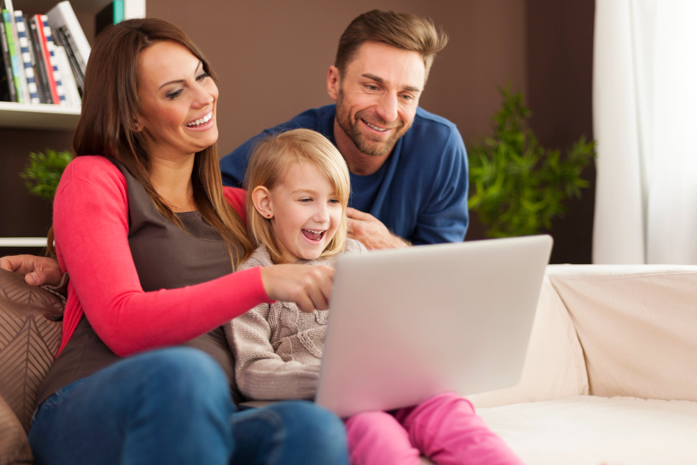 family-laughing-together-using-laptop-home